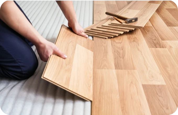 Closeup of worker installing laminate flooring on subfloor | Lloyd's Carpets & Draperies