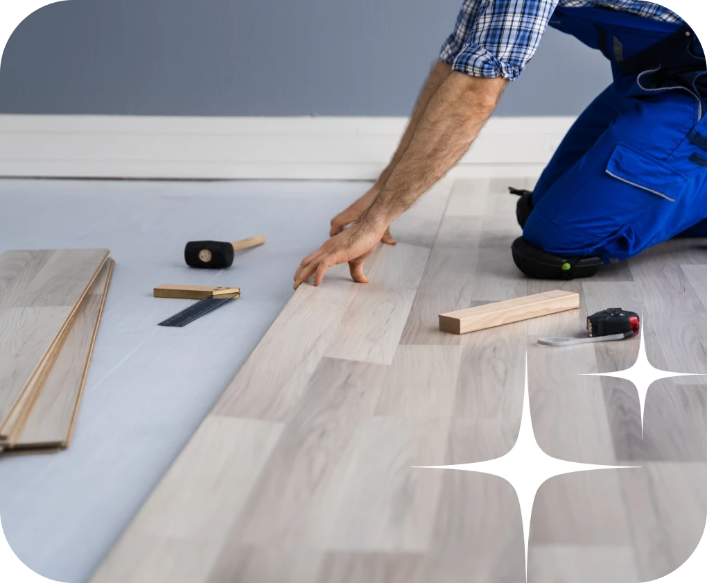 Worker wearing blue installing laminate flooring | Lloyd's Carpets & Draperies
