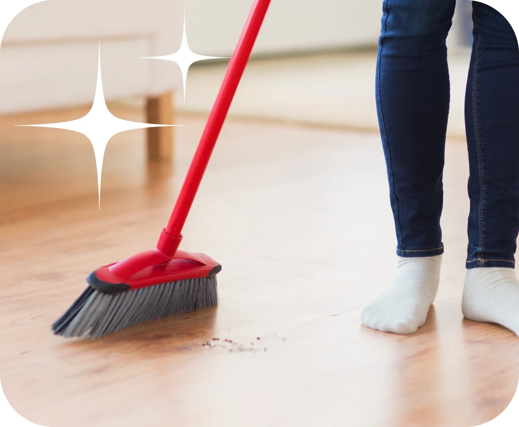 Homeowner sweeping dirt on luxury vinyl flooring close-up | Lloyd's Carpets & Draperies