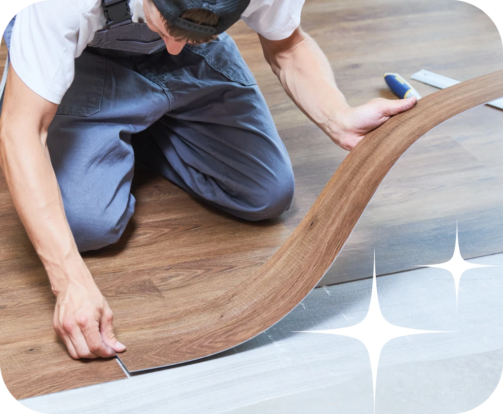 Worker installing luxury vinyl flooring close-up | Lloyd's Carpets & Draperies