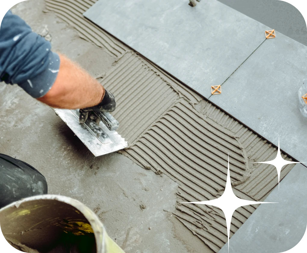 Worker installing tile with morter close-up | Lloyd's Carpets & Draperies